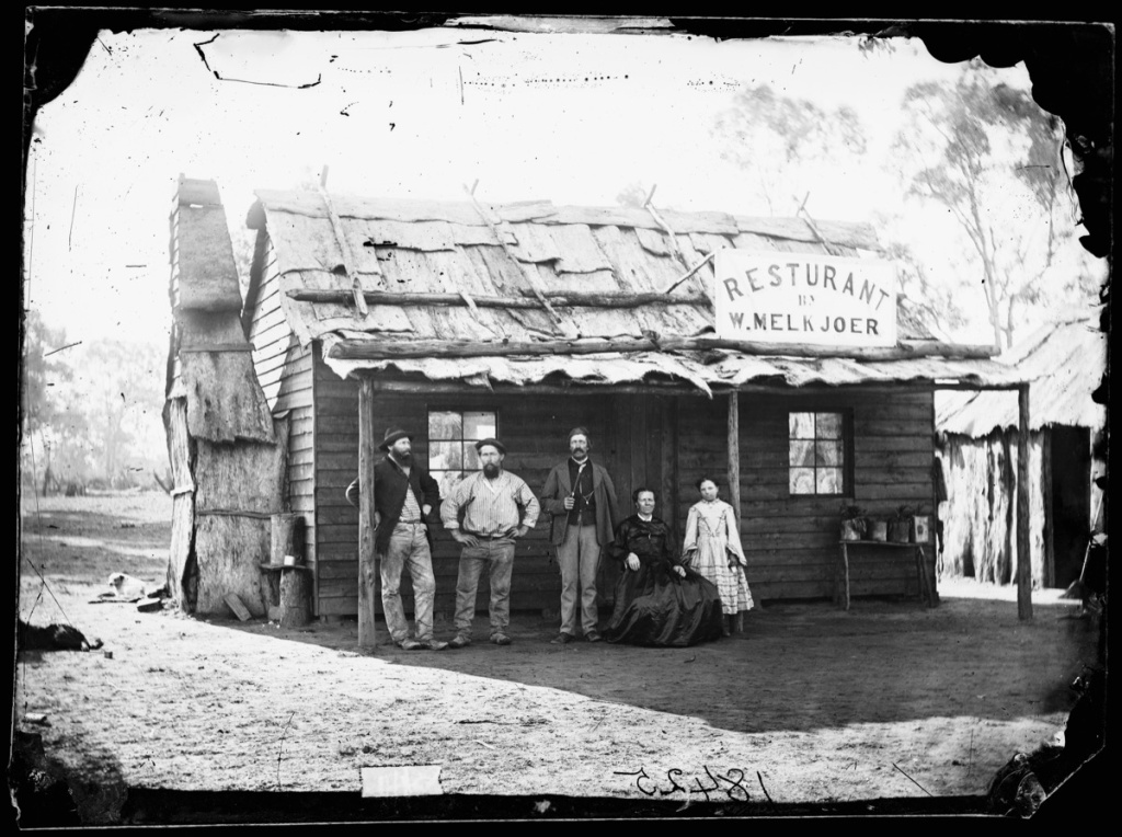 a2822351 - A group pose outside M Melkjoer's Restaurant, Home Rule.